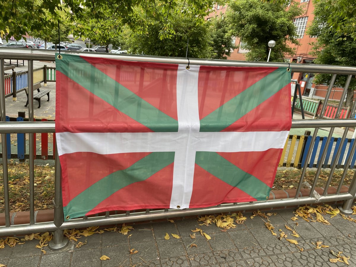 Ikurriña de 120 x 80 ctms con oiaos en las esquinas puesta en una valla.