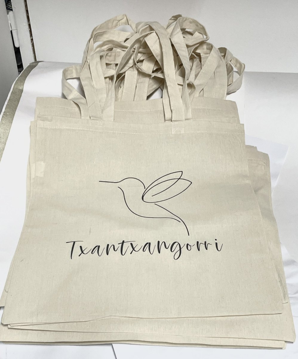 Tote bags de algodón natural personalizadas con un colibrí y la palabra Txantxangorri